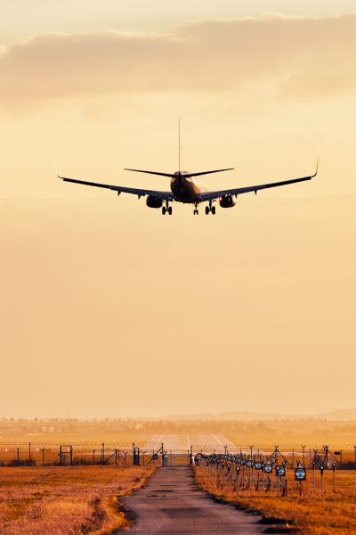airplane-flying-road-against-sky-sunset
